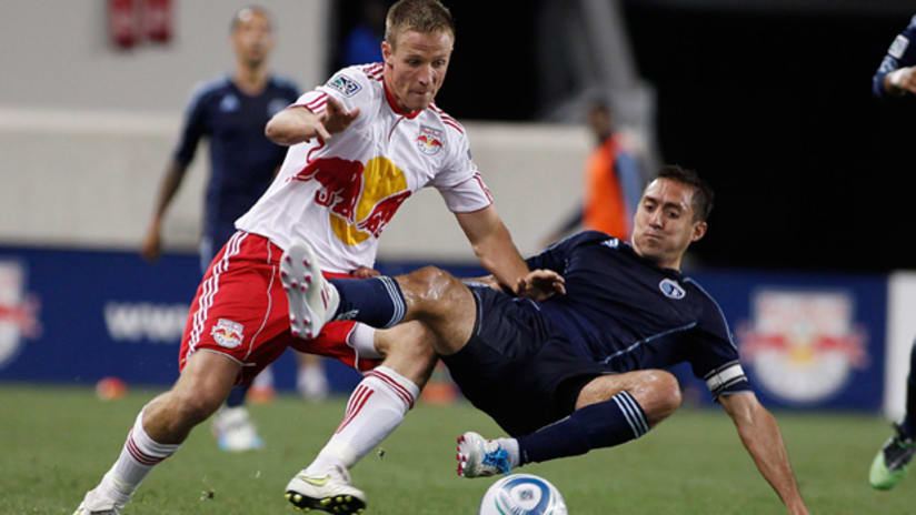 New York's Jan Gunnar Solli and Sporting's Davy Arnaud battle for a loose ball.